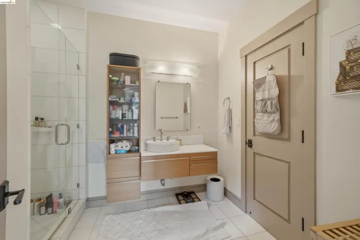 Shower with glass enclosure and white tiled walls