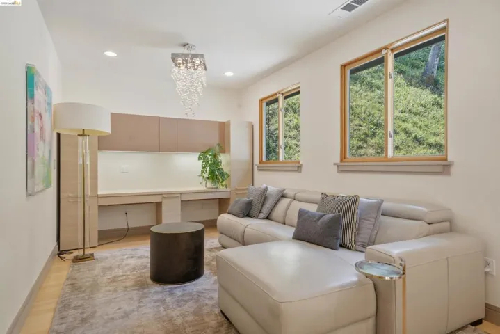Integrated desk with upper cabinetry, recessed lighting, and a contemporary chandelier