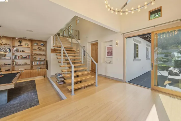 Hardwood flooring extending to a floating staircase with metal railing