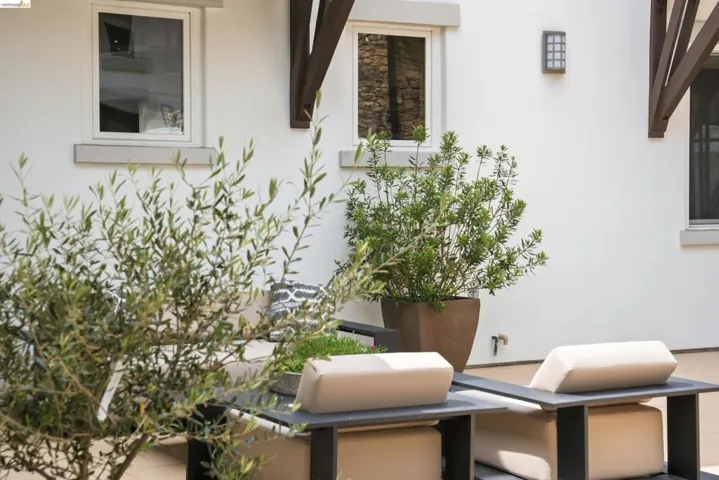 Private outdoor space featuring a white stucco exterior with architectural corbels and contemporary windows
