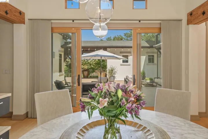 Spacious interior dining area featuring a round stone-finish table and glass pendant lighting