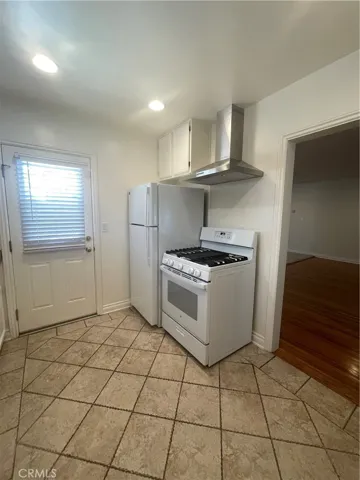 Kitchen With New Refrigerator and Vent Hood