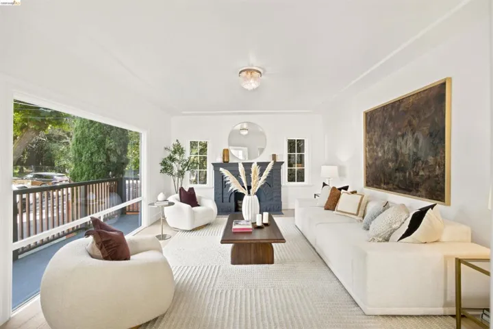Open-concept living space featuring a fireplace with a dark mantel, large sliding glass doors, recessed lighting, and a white ceiling