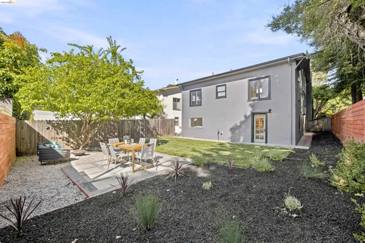 Rear exterior featuring a grey stucco finish and dark trim windows