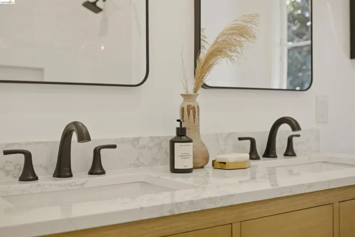 Dual undermount sinks with bronze-finish fixtures set in a stone-finish countertop