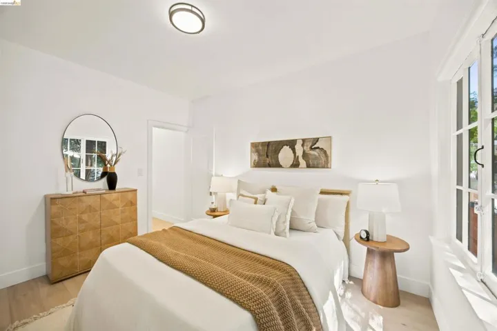Bright room featuring light wood-finish flooring, white walls, and a contemporary flush-mount ceiling light