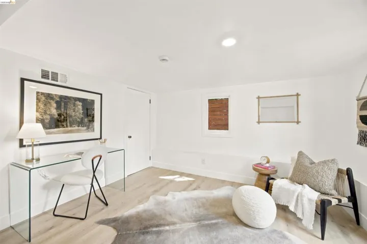 Bright room featuring light wood-finish flooring, white walls, and recessed lighting