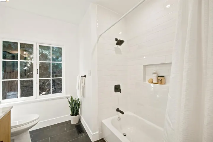 Bathroom featuring a white subway tile shower, built-in shower niche, and dark bronze fixtures