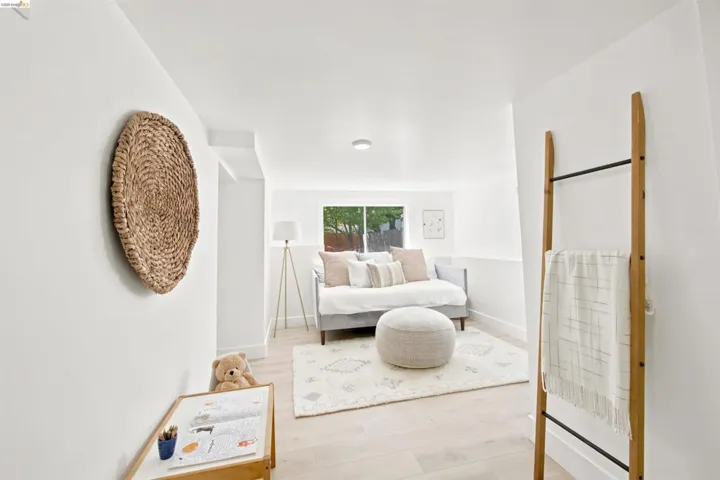Bright room with light wood-finish flooring, a window offering natural light, and a clean white color palette
