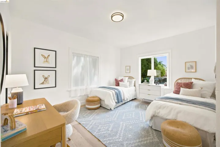 Bright interior space featuring a window with exterior visibility, wood-finish flooring, white walls, a flush-mount ceiling light, and a built-in window sill