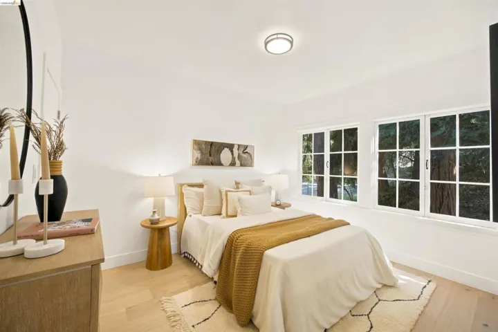 Light wood-finish flooring provides a bright base for this room featuring white walls and a contemporary flush-mount ceiling light