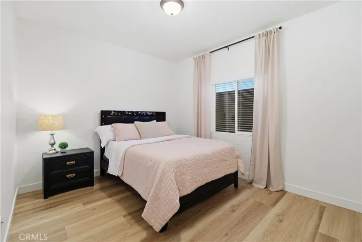 Secondary bedroom on main level with designer hardware and linen drapes