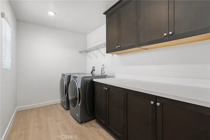 Upstairs laundry with ample cabinets, folding space & natural light