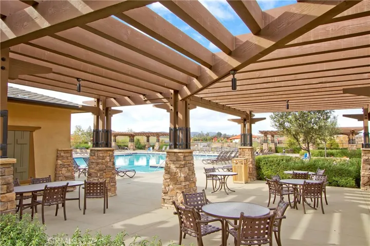 The Club features inviting outdoor tables for alfresco dining beneath a shaded pergola—an ideal setting for relaxed meals, casual gatherings, and enjoying the outdoors in comfort.