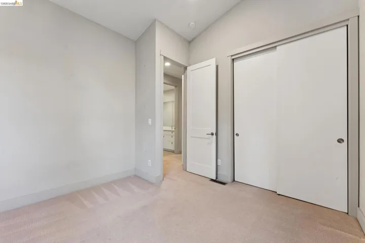Carpeted room with light gray wall paint and matching baseboards