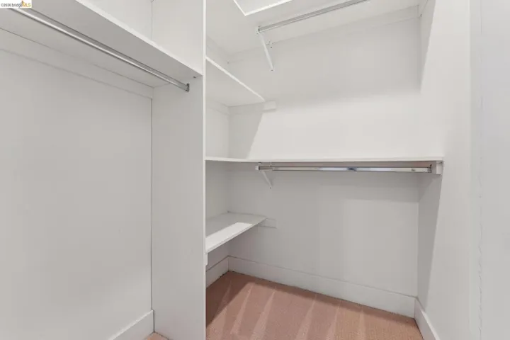 Custom closet system featuring multiple hanging rods and integrated shelving units