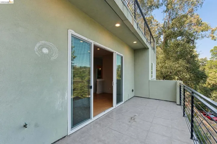 Balcony featuring tiled flooring and a contemporary black metal railing