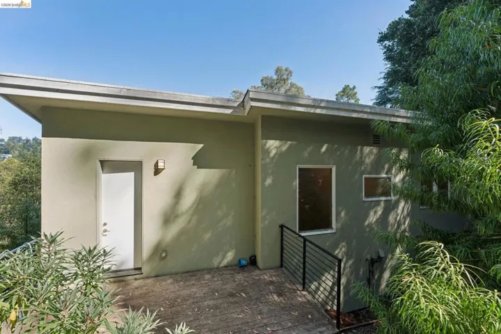 Exterior stucco walls featuring a flat roofline and a private entrance