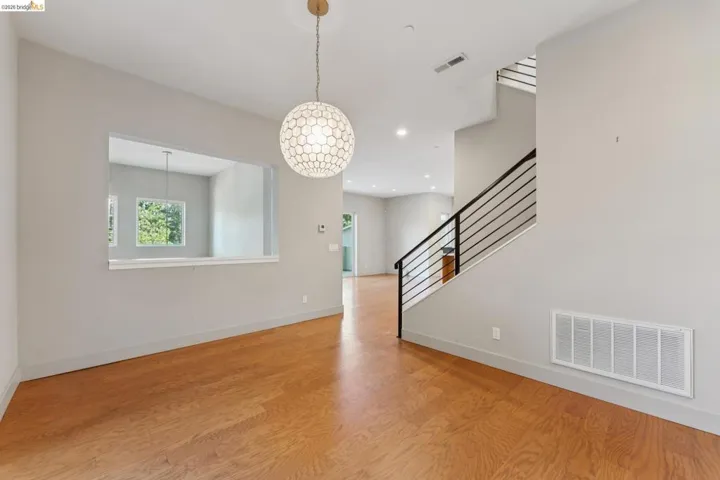 Hardwood flooring throughout the main level, complemented by a modern spherical pendant light