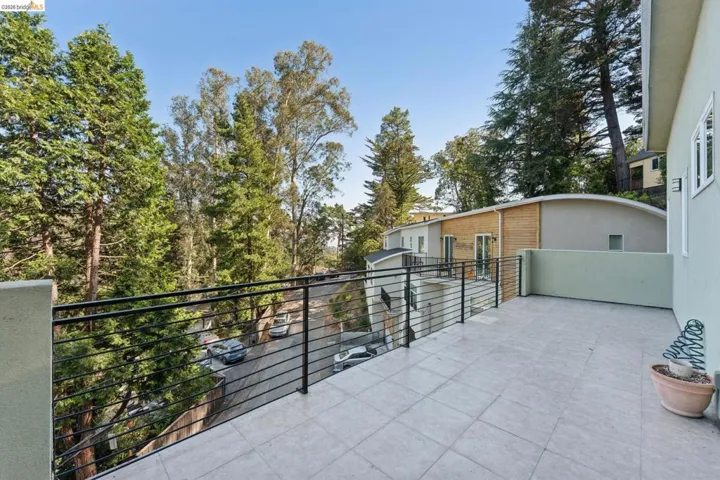 Spacious outdoor deck featuring tile flooring and a black horizontal bar railing