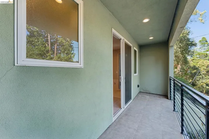 Private balcony featuring a stucco exterior, tiled flooring, recessed lighting, and a modern horizontal bar railing
