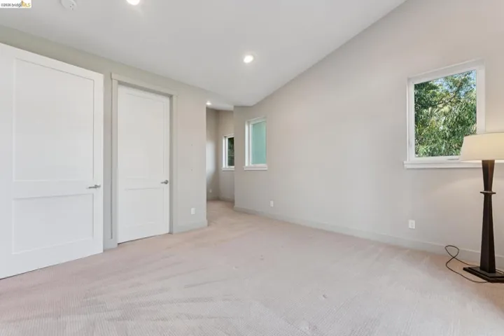 Expansive room featuring light-toned carpeting and multiple windows