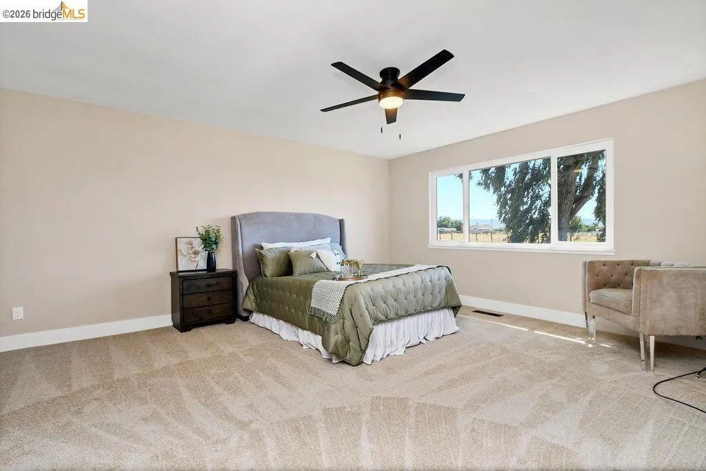Spacious room featuring neutral carpeting and light-toned walls
