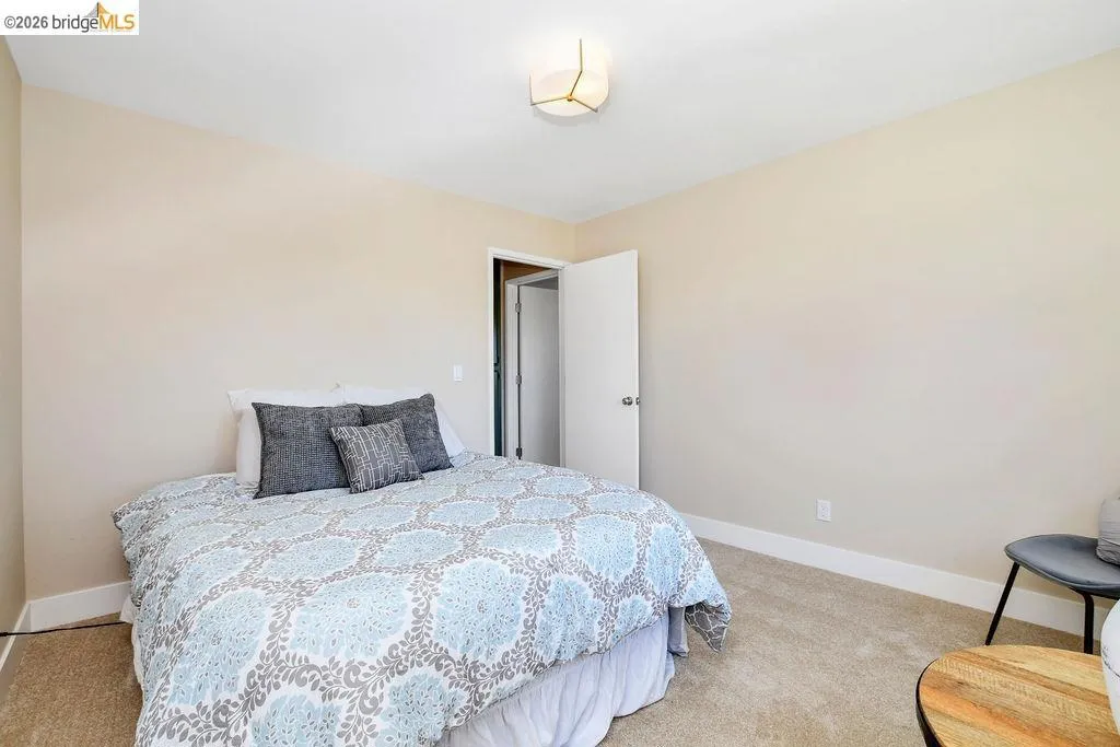 Carpeted room with a modern ceiling light fixture, neutral wall color, and white baseboards