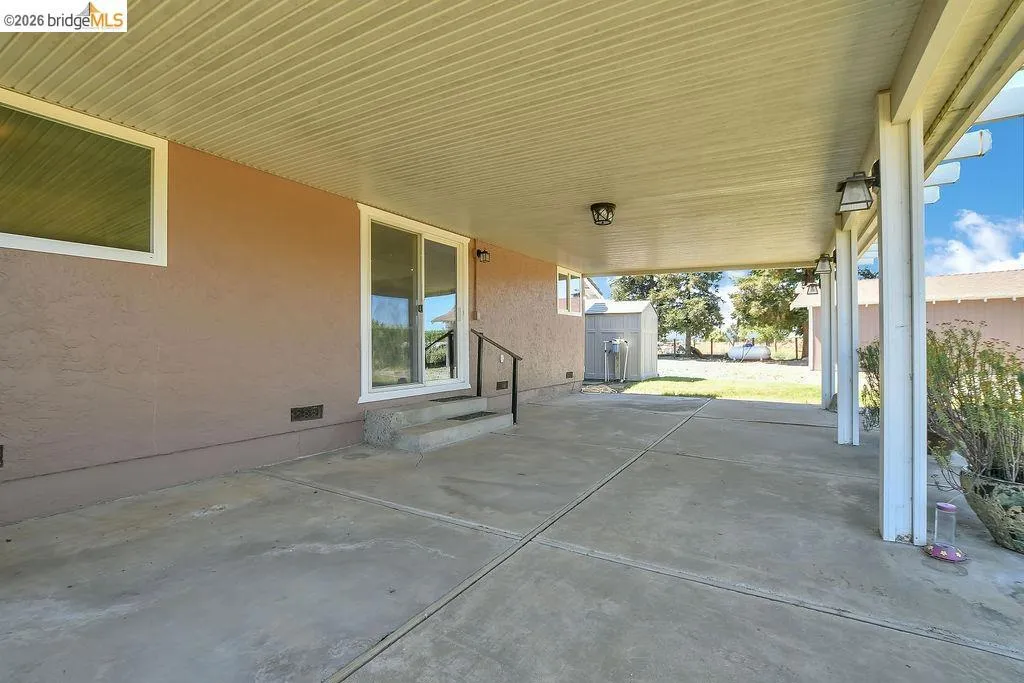 Expansive covered patio featuring concrete flooring and a stucco exterior
