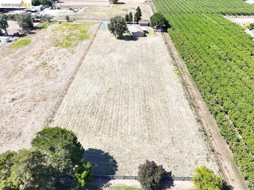 Expansive undeveloped lot featuring a rectangular shape and a perimeter fence