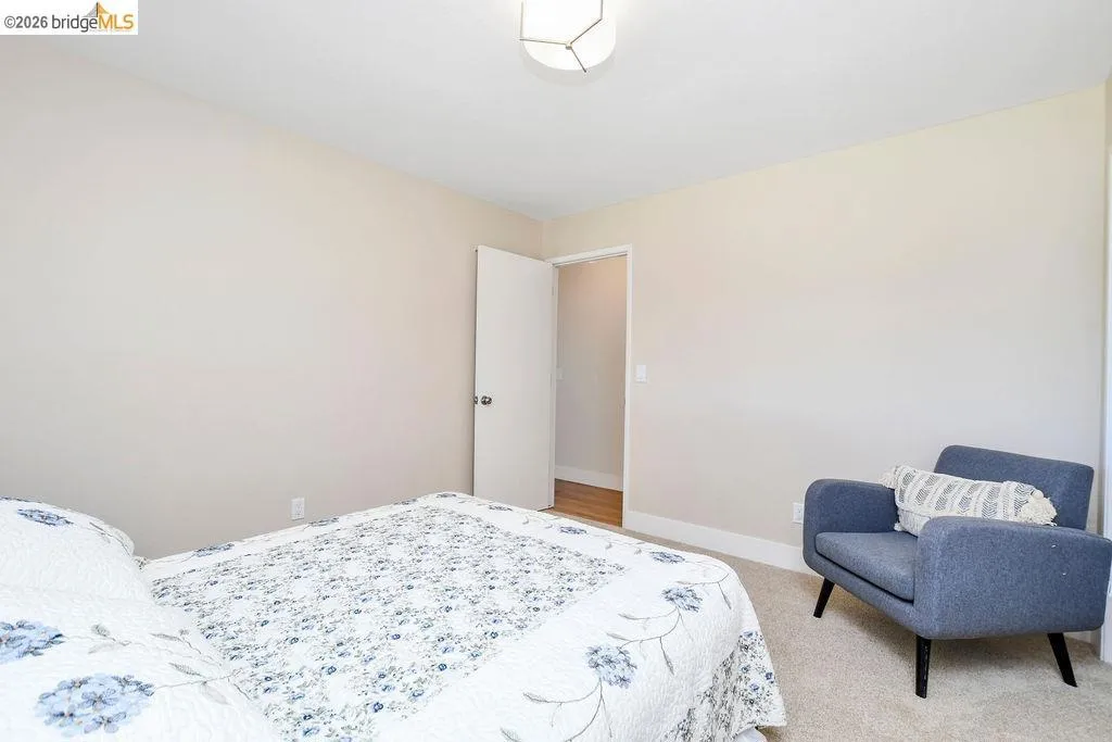 Carpeted bedroom with neutral wall paint and white trim