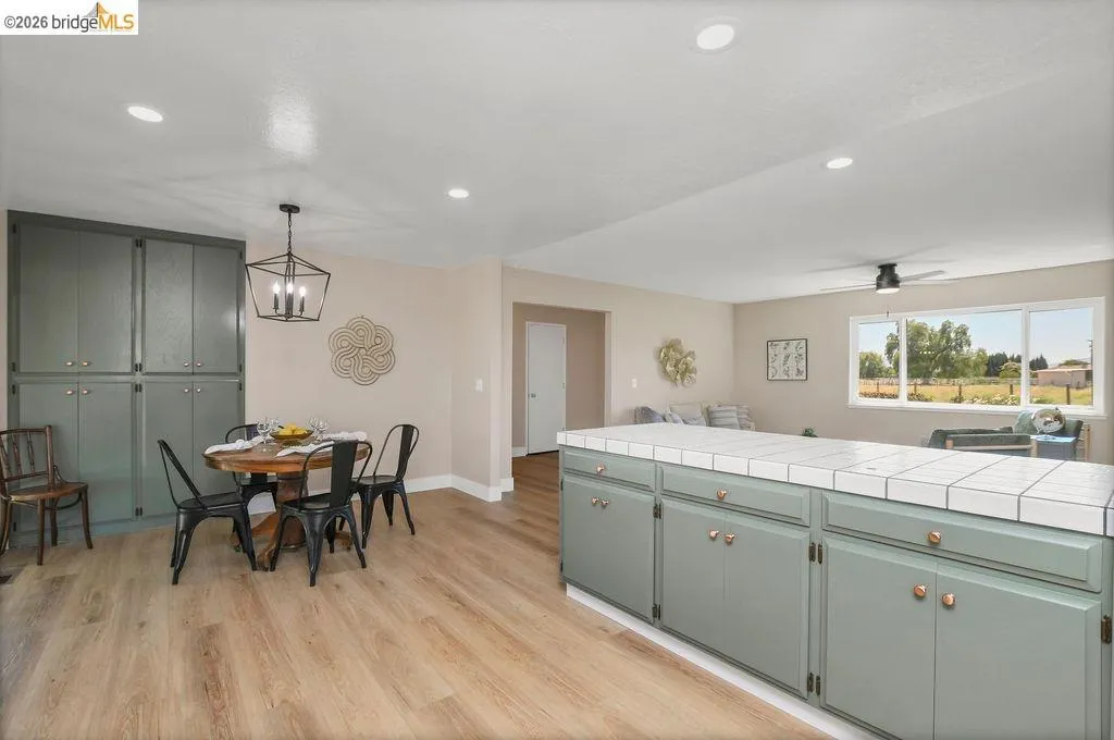 Open-concept living space featuring wood-finish flooring, recessed lighting, and a window with exterior visibility