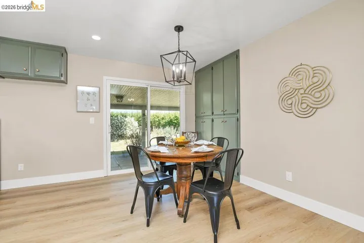 Dining area with wood-finish flooring, recessed lighting, and a contemporary chandelier