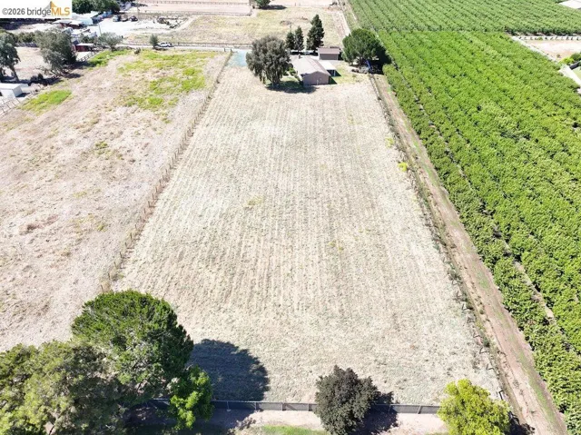 Expansive undeveloped lot featuring a rectangular shape and a perimeter fence