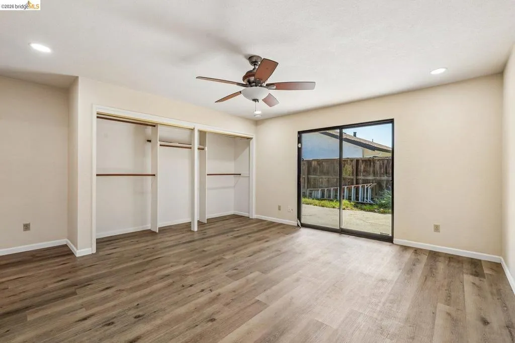 Spacious room featuring wood-finish flooring, recessed lighting, and a ceiling fan