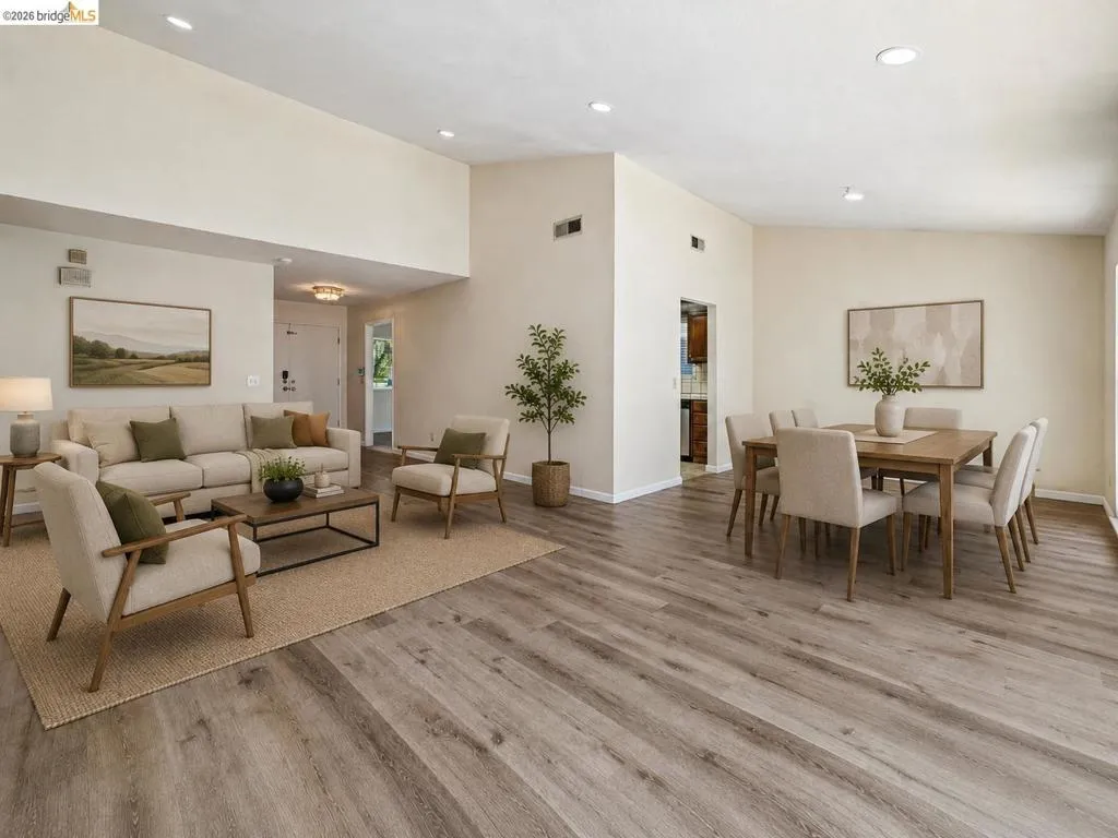 Open-concept living and dining areas featuring vaulted ceilings, recessed lighting, and wood-finish flooring
