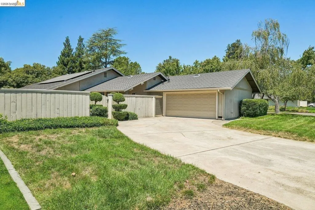 Exterior featuring a two-car garage, a concrete driveway, and a sloped roofline