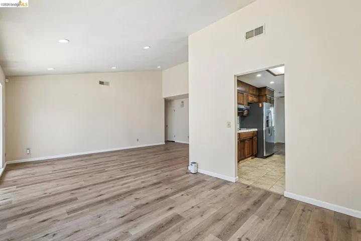 Spacious living area featuring wood-finish flooring, recessed lighting, and vaulted ceilings
