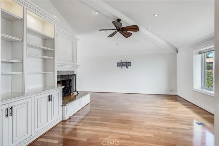 Living room with fireplace, high ceilings and custom wall cabinets and ocean view