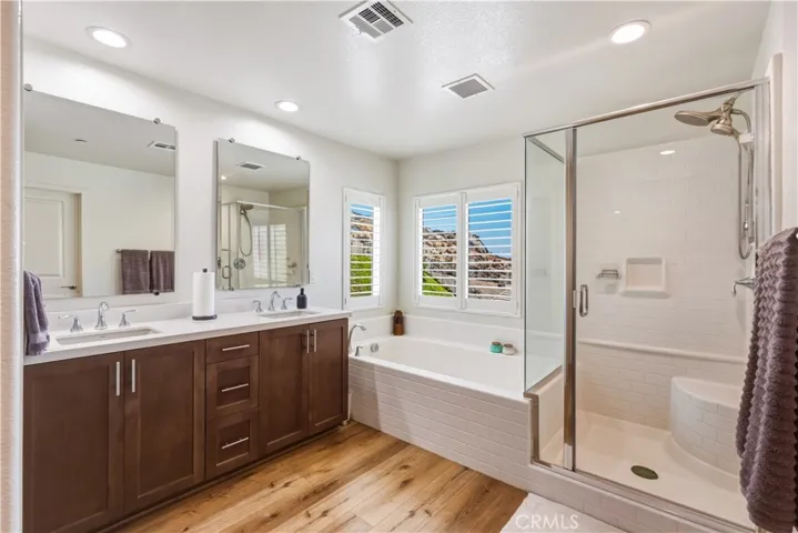 double vanity sink, garden tub and walk in shower in primary bath