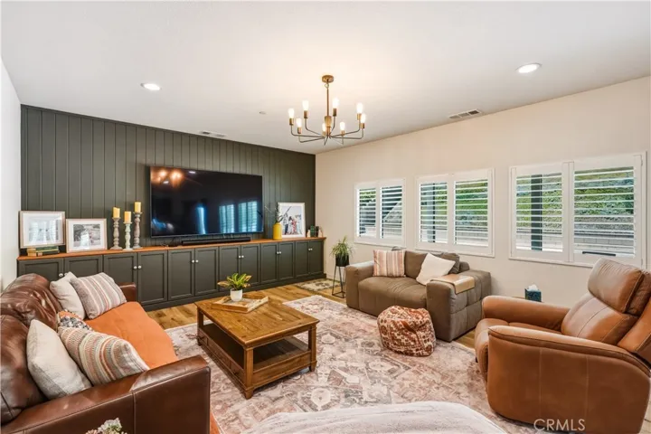 living room with built in cabinets and plantation shutters