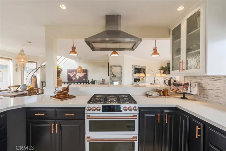 Cooktop stove and oven with a view of the dining room and comfortable bar top eating area in front of the stove