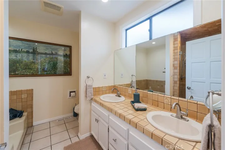 Dual sinks in the main bath with tub and privacy area