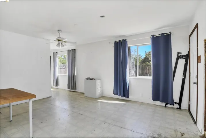 Bright interior space with white walls and a ceiling fan