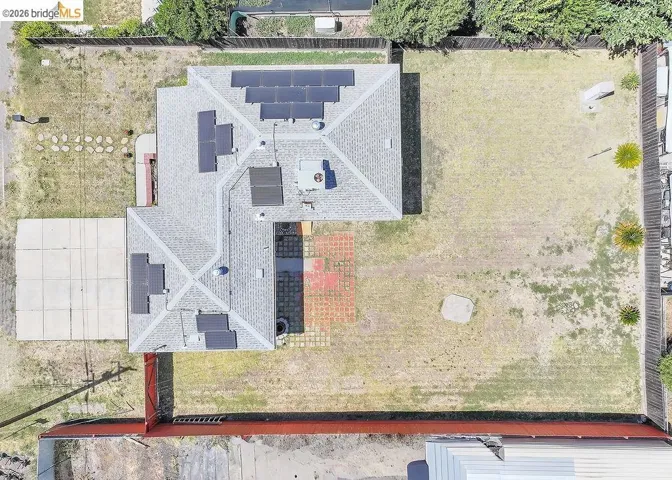 Aerial perspective showcasing a shingled roofline with multiple solar panel installations