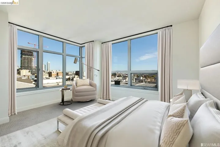 Corner bedroom featuring expansive windows with cityscape scenery