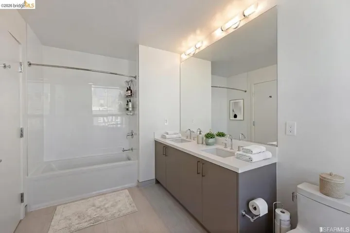 Contemporary bathroom featuring a double vanity with quartz countertop, dual integrated sinks, and polished chrome fixtures