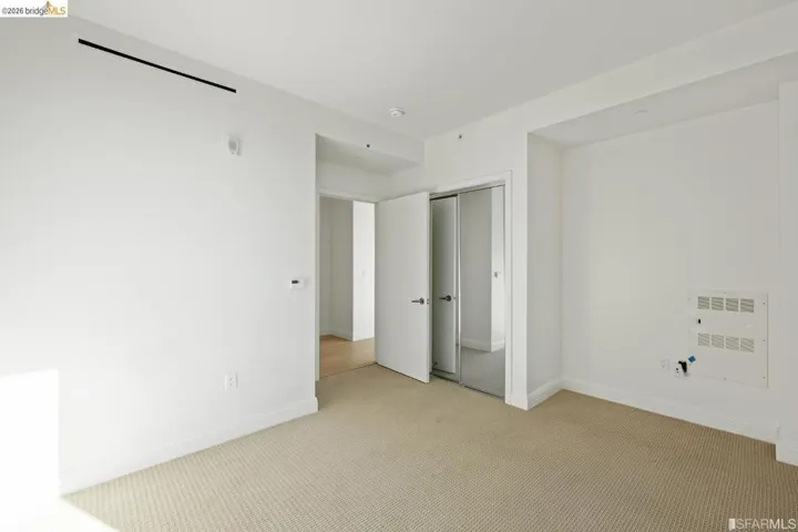 Spacious room featuring neutral carpet flooring and white walls