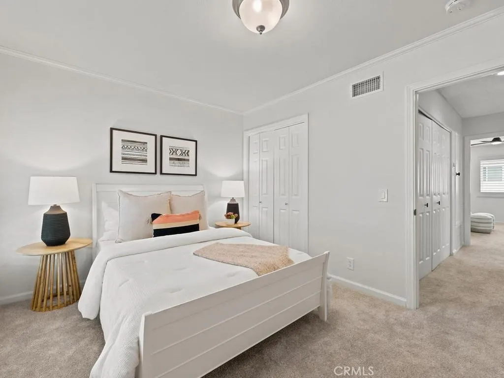 Front bedroom with split plantation shutters and crown molding.