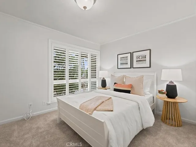Front bedroom with split plantation shutters and crown molding.